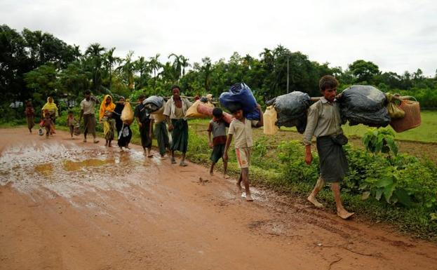 Varios refugiados caminan hacia la frontera./Reuters