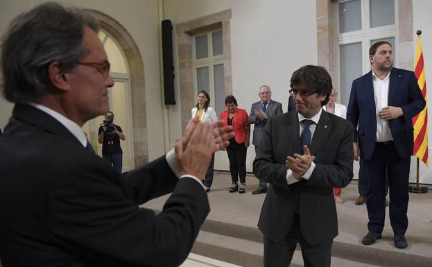 Mas (i) aplaude a Puigdemont. /Lluís Gené (Afp)