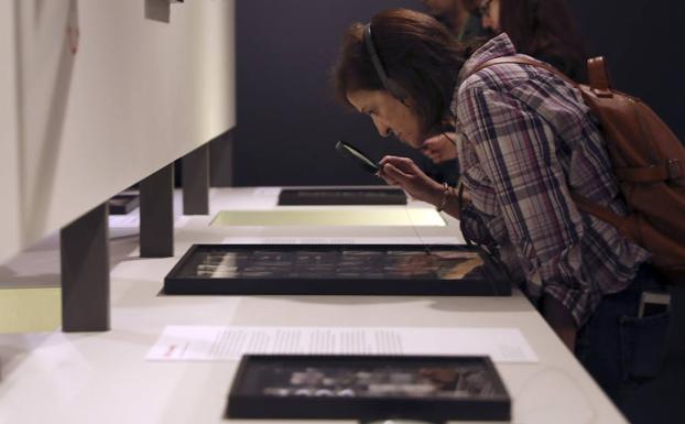 Una mujer observa algunos negativos que se pueden contemplar en la exposición 'Magnum: Hojas de contacto'. /J. J. Guillén (Efe)