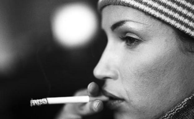 Una mujer fumando./