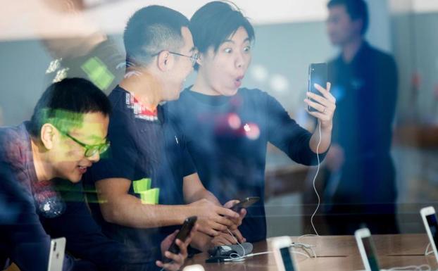 Cliente prueba el nuevo teléfono de la marca en una tienda de China./Afp