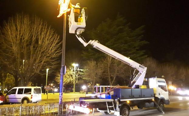 Imagen de un vehículo municipal realizando reparaciones de la iluminación navideña./