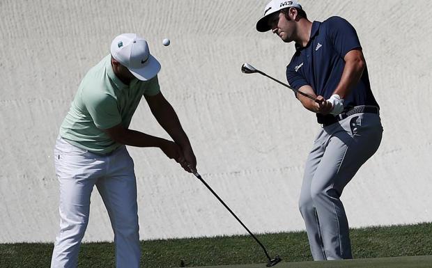 Jon Rahm golpea la bola junto al sueco Alex Noren durante el entrenamiento de ayer./Efe