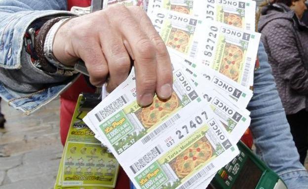 Un vendedor de la Once muestra varios cupones de la lotería.