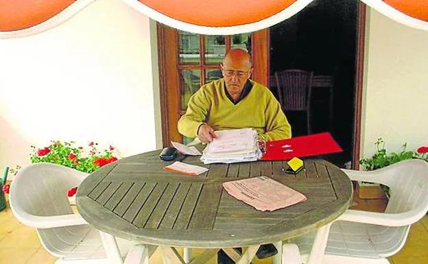 Santi Oleaga, con unos papeles en la mesa de su terraza. /