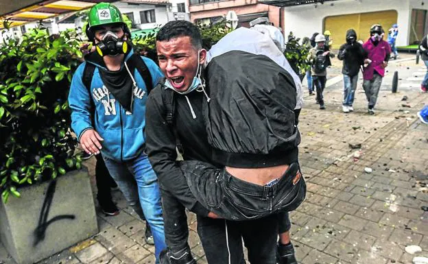 Evacuación de un joven herido por disparos de la Policía en Medellín./afp