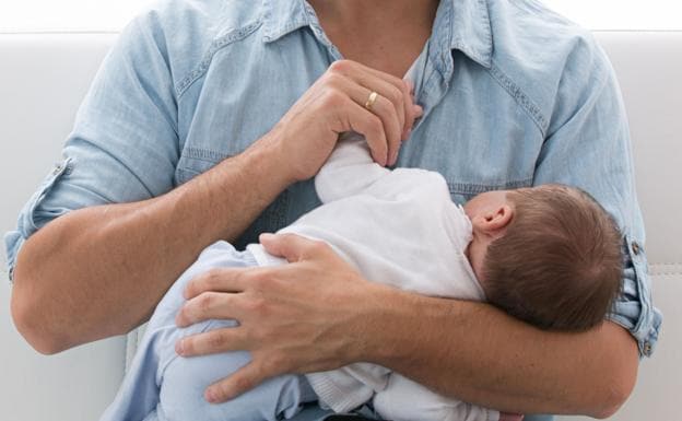 Un padre con su bebé en brazos./Lola Fernández