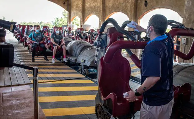 Un trabajador de PortAventura da instrucciones a los visitantes en una montaña rusa tras la reapertura del parque. /R. C.