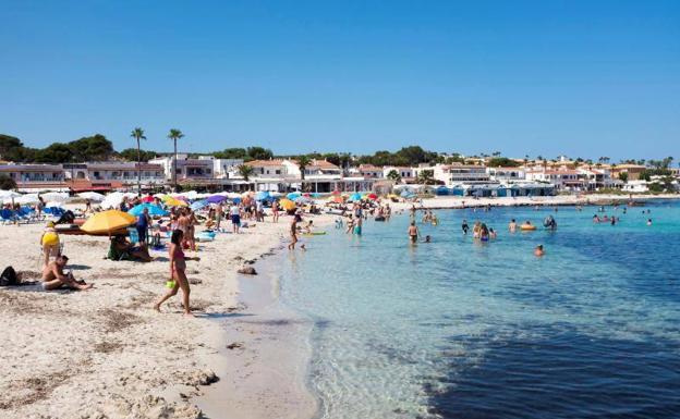 Decenas de personas disfrutan de un día soleado en una playa de Menorca./efe