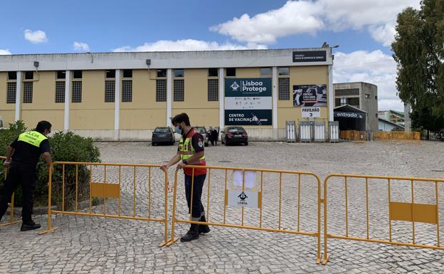 Agentes de la Policía Municipal portuguesa colocan vallas en el Estadio Universitario de Lisboa, reconvertido en centro de vacunación masiva. /Efe