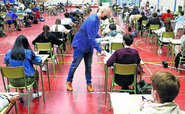 Un profesor reparte exámenes en un aula. /R. C.