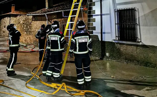Los Bomberos de León, durante su intervención en el incendio de una vivienda en Lugán.