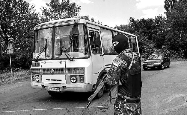 Un soldado ucraniano revisa autobuses en un cruce próximo a la linea del frente