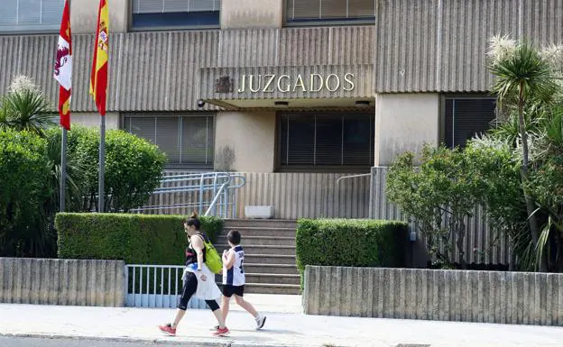 Una madre y su hijo pasean ante el edificio de los Juzgados en Miranda de Ebro (Burgos). /avelino gómez