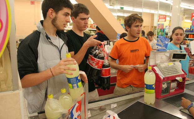 Jovenes compran bebida en un supermercado de Vitoria./J. Montes