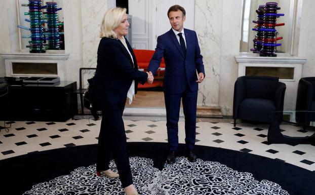 Marine Le Pen salue Emmanuel Macron avant leur rencontre à l'Elysée mardi.